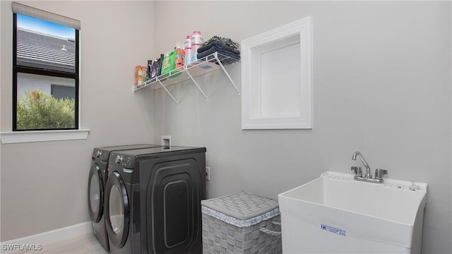 laundry room with washing machine and clothes dryer, laundry area, a healthy amount of sunlight, and a sink