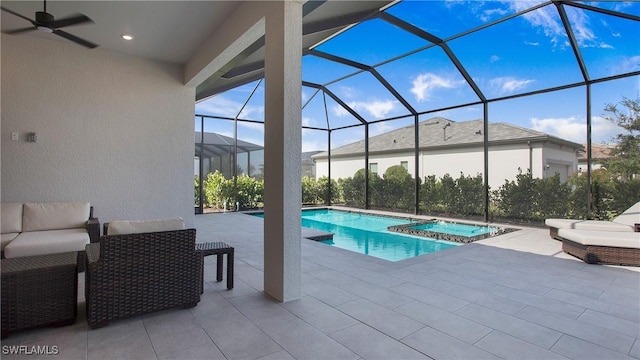 view of swimming pool with a pool with connected hot tub, a lanai, outdoor lounge area, ceiling fan, and a patio area