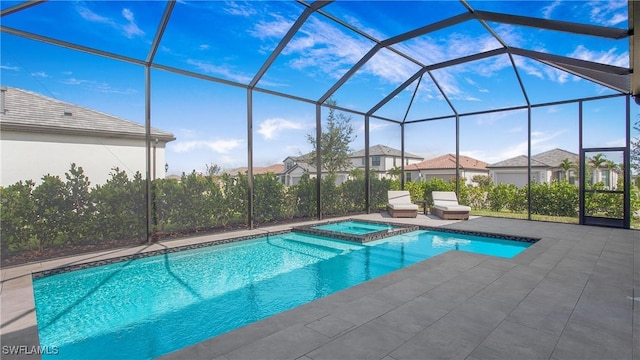 view of pool featuring glass enclosure, a patio, and a pool with connected hot tub