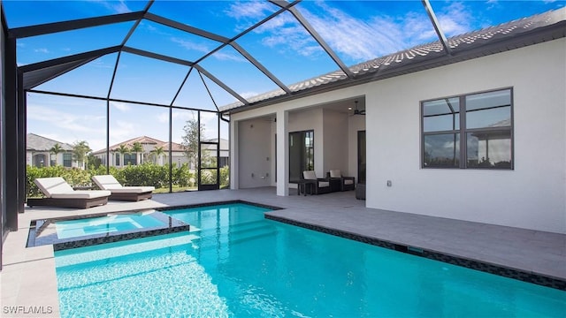 view of pool with an outdoor living space, a pool with connected hot tub, ceiling fan, glass enclosure, and a patio area