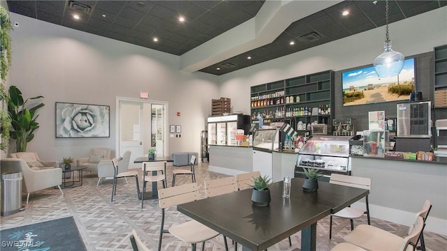 dining space with visible vents and a high ceiling