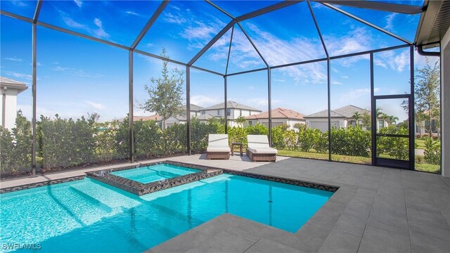 view of pool featuring a lanai, a patio area, and an in ground hot tub