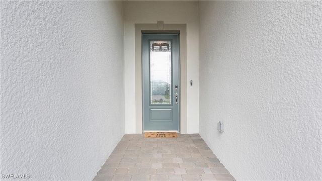 doorway to property featuring stucco siding