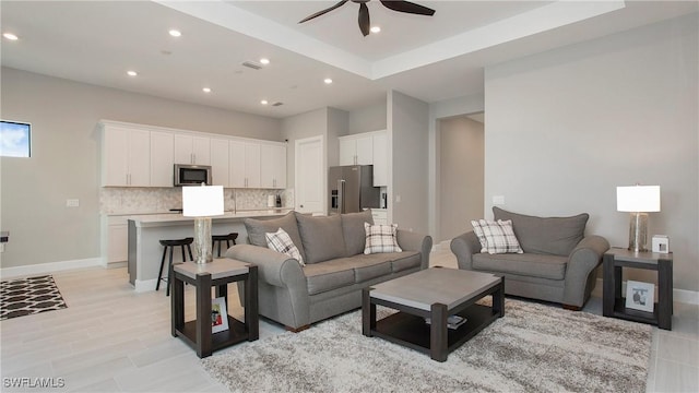 living area featuring recessed lighting, baseboards, light wood-style floors, and ceiling fan