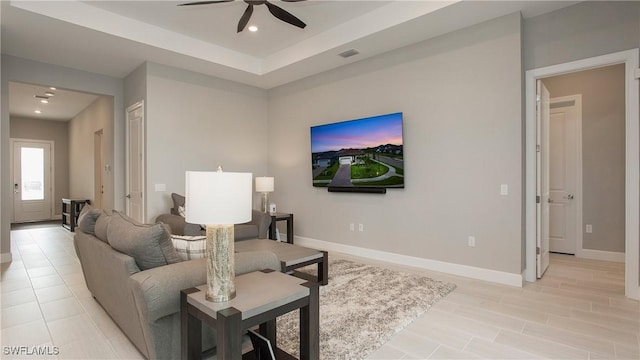 living area featuring visible vents, baseboards, recessed lighting, a raised ceiling, and a ceiling fan