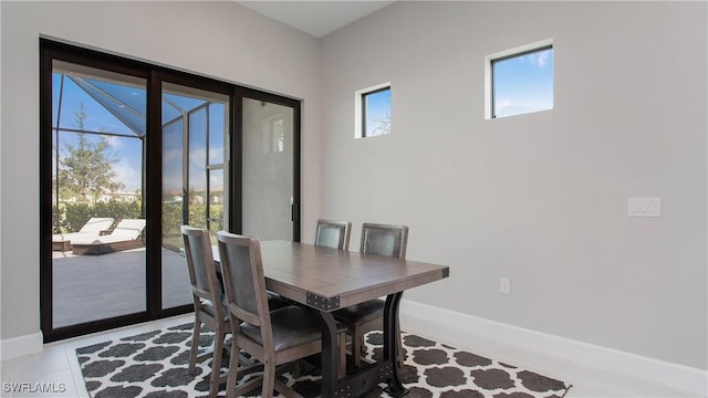 dining space featuring baseboards and plenty of natural light