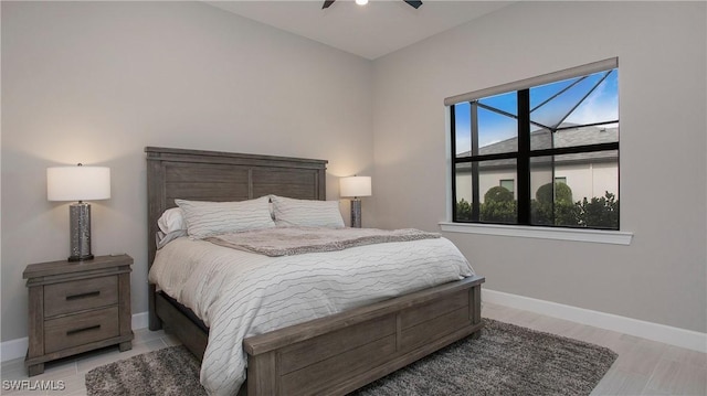 bedroom with light wood finished floors, ceiling fan, and baseboards