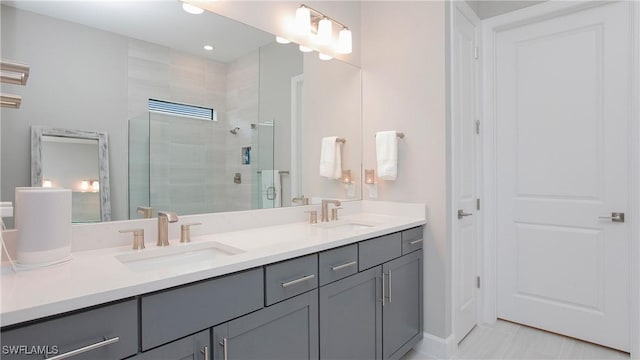 bathroom featuring double vanity, a stall shower, and a sink