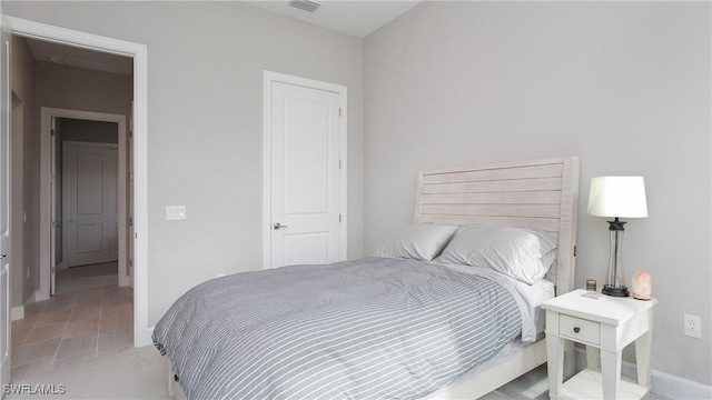 bedroom with baseboards and visible vents