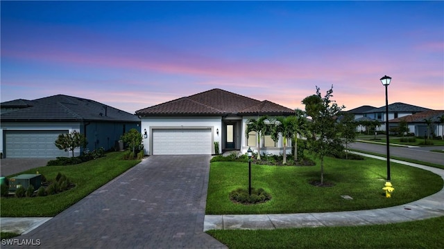 view of front of property featuring a garage and a yard