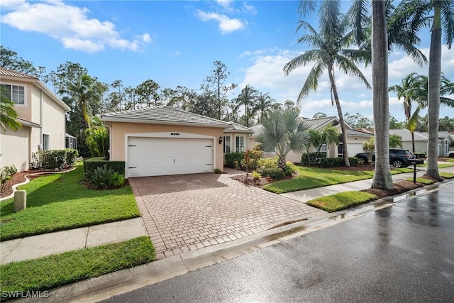 single story home with a garage and a front lawn