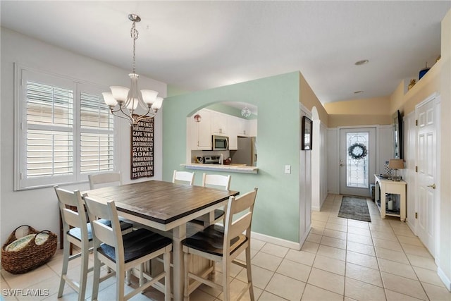 dining space with a chandelier and light tile patterned floors