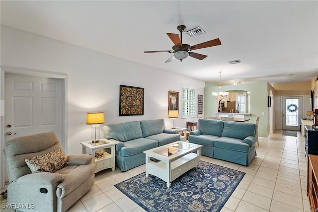 tiled living room featuring ceiling fan with notable chandelier and a wealth of natural light