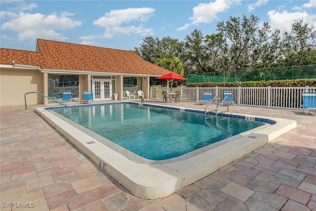 view of swimming pool with french doors and a patio