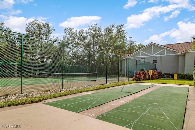 view of community featuring tennis court