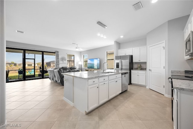 kitchen featuring white cabinetry, ceiling fan, an island with sink, and stainless steel appliances