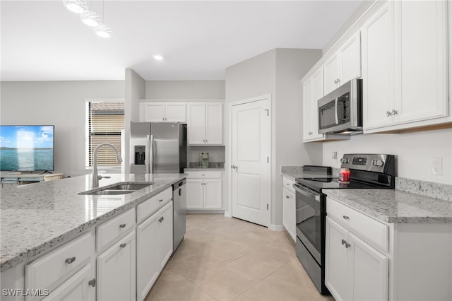 kitchen with light stone countertops, white cabinetry, sink, and appliances with stainless steel finishes