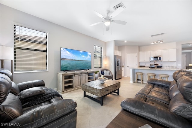 tiled living room with ceiling fan