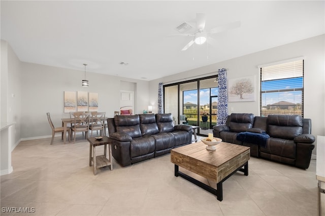 tiled living room with plenty of natural light and ceiling fan