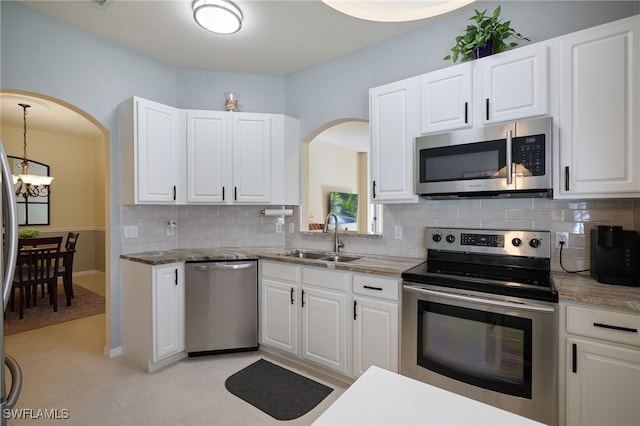 kitchen with sink, light tile patterned floors, a notable chandelier, white cabinetry, and stainless steel appliances