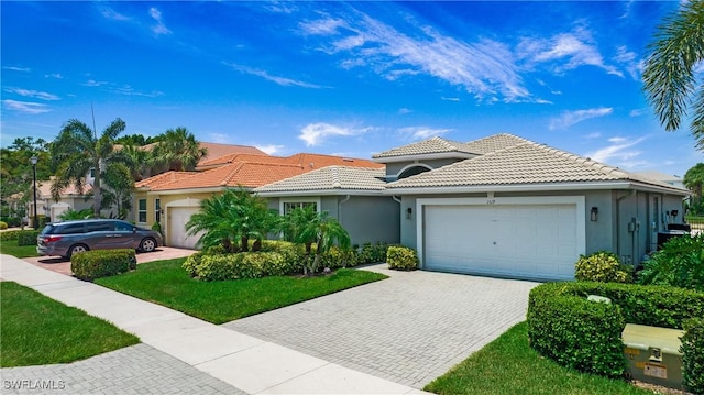 mediterranean / spanish-style home with a garage and a front lawn