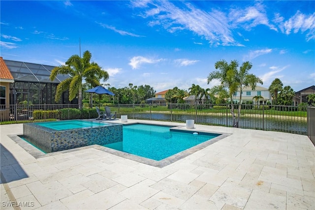 view of pool featuring a lanai, a water view, fence, a pool with connected hot tub, and a patio area