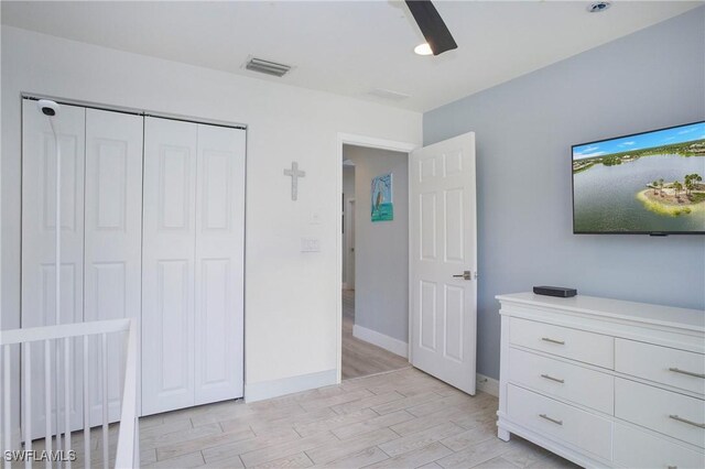 unfurnished bedroom with a closet, visible vents, light wood-style floors, ceiling fan, and baseboards