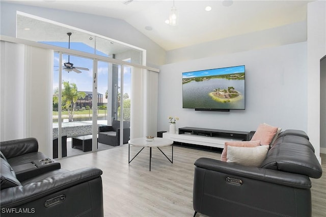 living area with high vaulted ceiling, light wood finished floors, and a ceiling fan