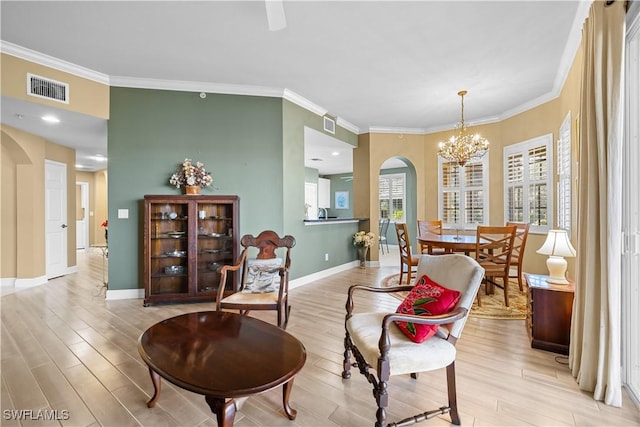 living area with light hardwood / wood-style floors, crown molding, and a chandelier