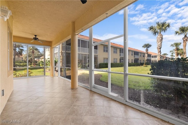 unfurnished sunroom featuring ceiling fan