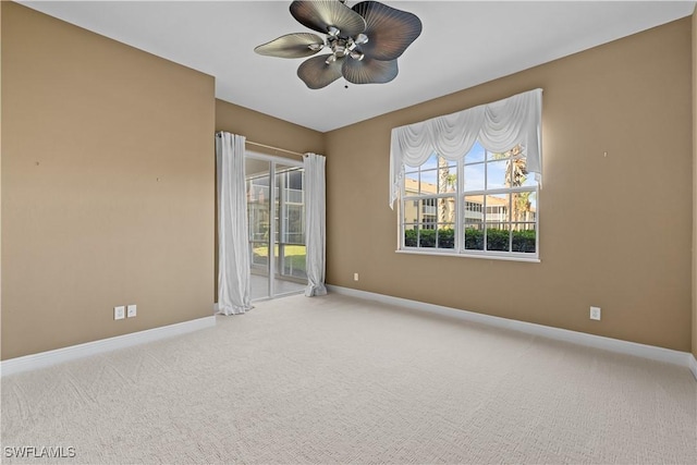 carpeted spare room featuring ceiling fan