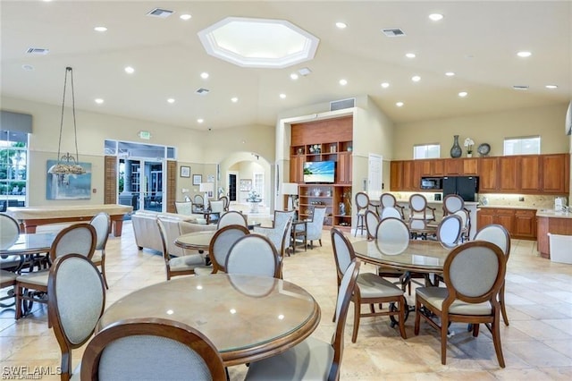 dining area with light tile patterned floors and a high ceiling