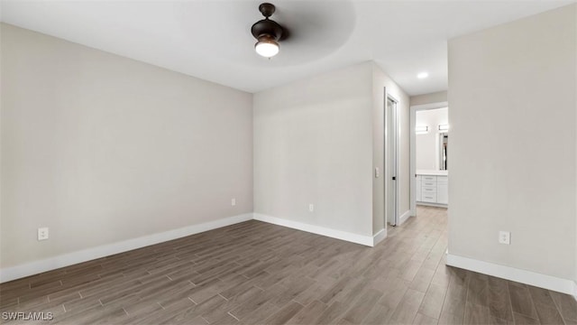 unfurnished room with a ceiling fan, baseboards, and wood finished floors