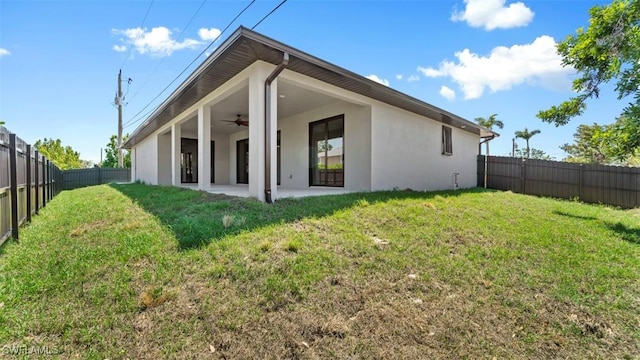 rear view of property with a yard, a patio, and ceiling fan