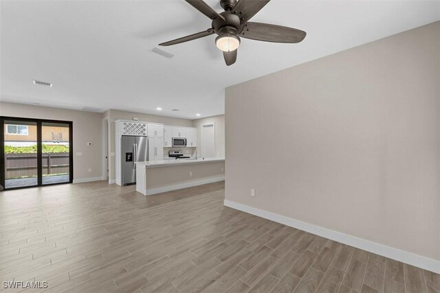 unfurnished living room featuring ceiling fan and light hardwood / wood-style floors