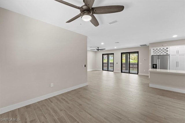 unfurnished living room with ceiling fan and light hardwood / wood-style flooring