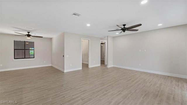 empty room with ceiling fan and light hardwood / wood-style flooring