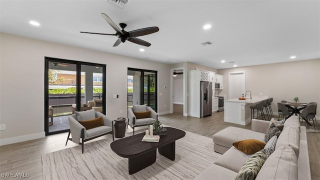 living room featuring recessed lighting, visible vents, and light wood-style flooring