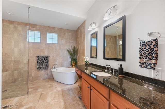 bathroom with vanity, separate shower and tub, and tile walls