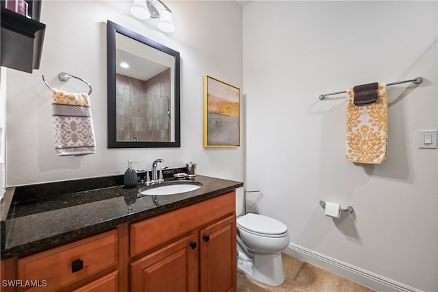 bathroom with tile patterned flooring, vanity, toilet, and walk in shower