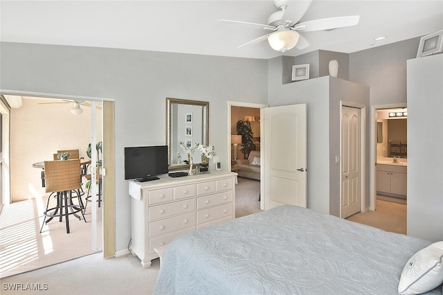 bedroom with ceiling fan, sink, light carpet, and connected bathroom