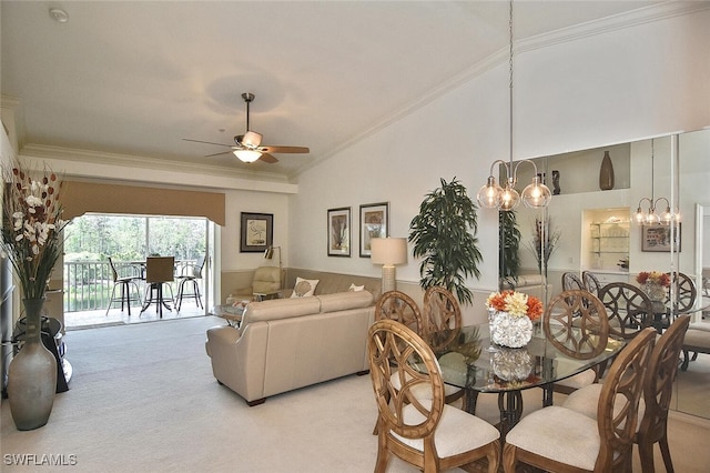 dining space featuring light carpet, ceiling fan with notable chandelier, lofted ceiling, and ornamental molding