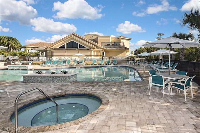 view of swimming pool with a patio and a hot tub