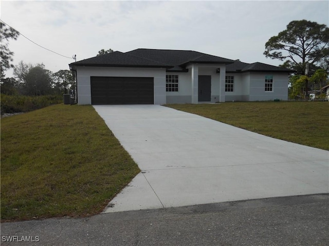 prairie-style home featuring a garage and a front lawn