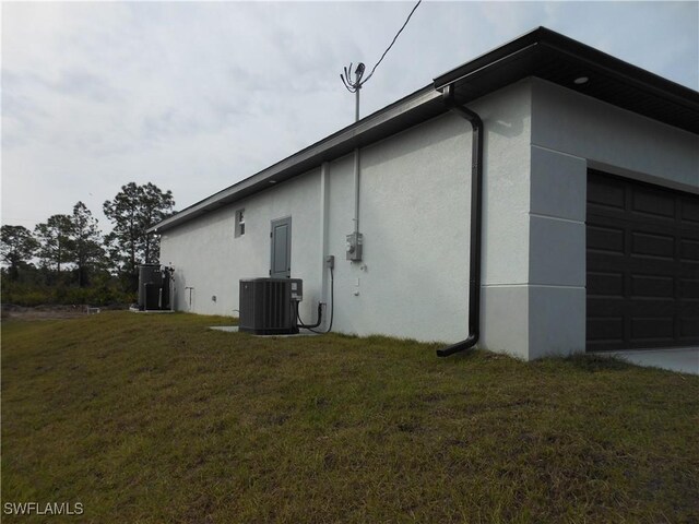 view of home's exterior with cooling unit and a yard