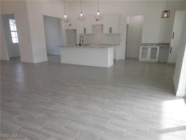 unfurnished living room with sink and a towering ceiling