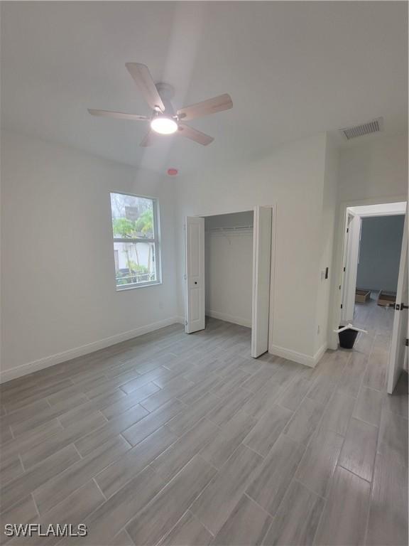 unfurnished bedroom with ceiling fan and a closet