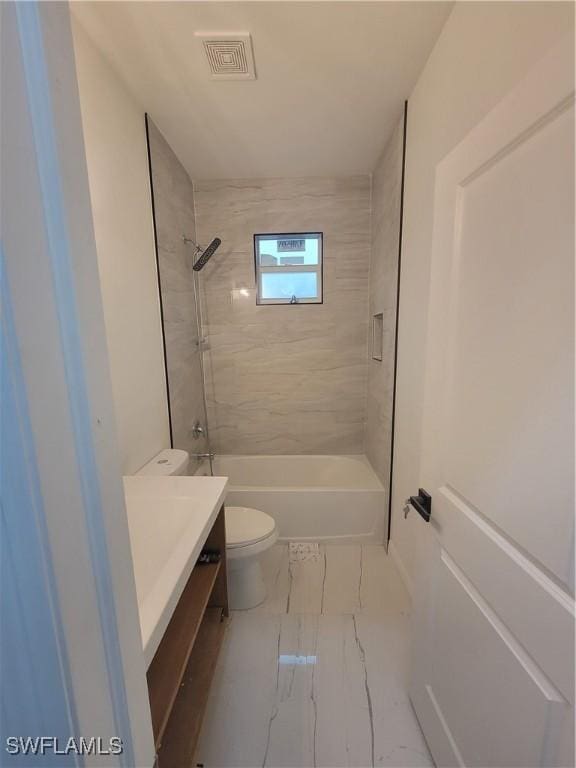 full bathroom featuring vanity, tiled shower / bath combo, and toilet