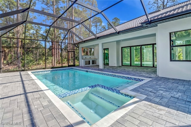 view of swimming pool featuring a lanai, a patio area, and an in ground hot tub