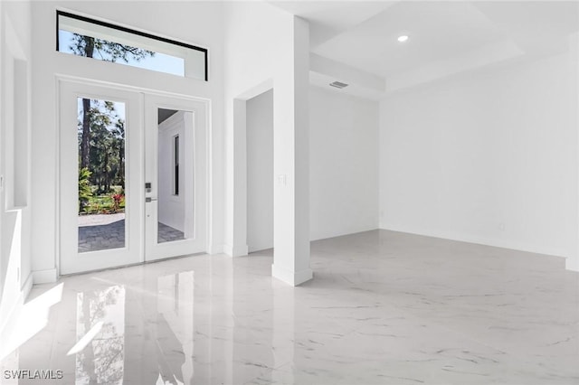 foyer entrance featuring a tray ceiling and french doors